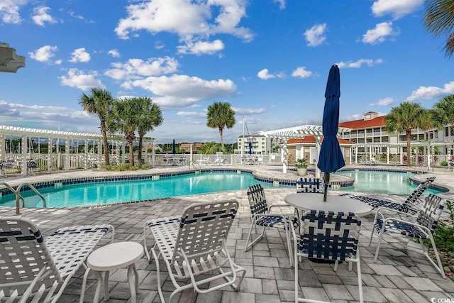 community pool featuring fence and a patio area