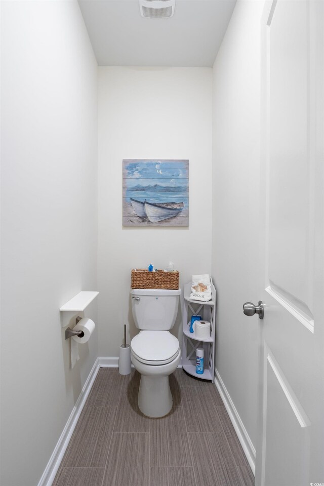 179 S Reindeer Rd, Surfside Beach, SC 29575 - bathroom featuring visible vents, toilet, and baseboards