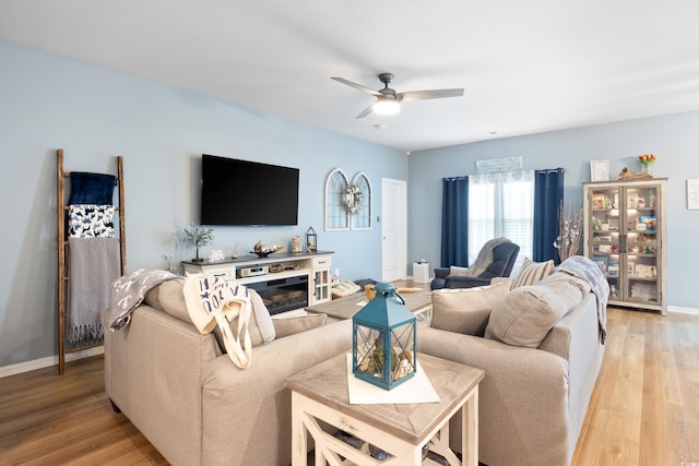 179 S Reindeer Rd, Surfside Beach, SC 29575 - living room featuring ceiling fan, baseboards, a glass covered fireplace, and light wood-type flooring