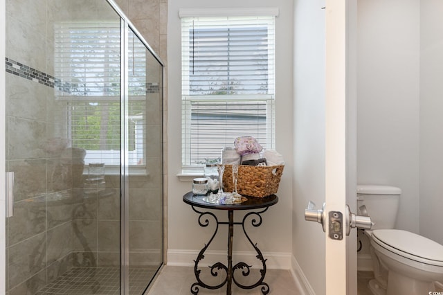 full bath featuring plenty of natural light, baseboards, a shower stall, and toilet