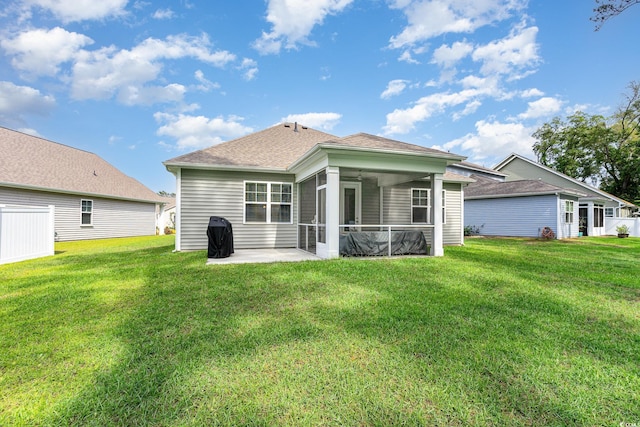 back of property featuring a shingled roof, a sunroom, a yard, and a patio