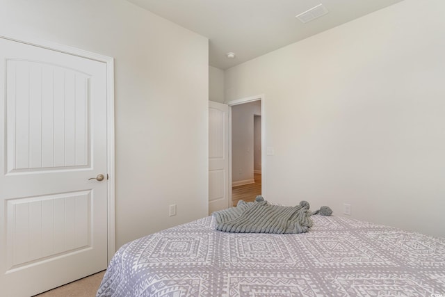 bedroom with visible vents and light colored carpet