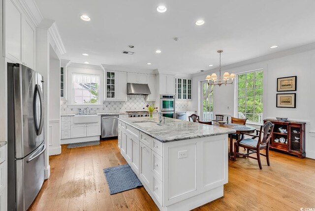 486 Lantana Cir, Georgetown, SC 29440 - kitchen with appliances with stainless steel finishes, under cabinet range hood, a sink, ornamental molding, and a chandelier