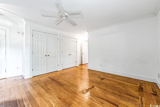 486 Lantana Cir, Georgetown, SC 29440 - unfurnished bedroom with crown molding, two closets, light wood-type flooring, baseboards, and a ceiling fan