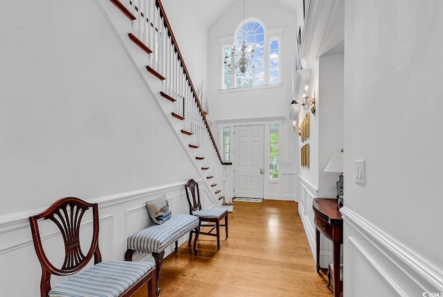 486 Lantana Cir, Georgetown, SC 29440 - foyer entrance featuring stairs, a towering ceiling, a decorative wall, a wainscoted wall, and light wood-style floors