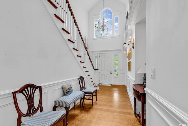 486 Lantana Cir, Georgetown, SC 29440 - foyer entrance featuring stairs, a towering ceiling, a decorative wall, a wainscoted wall, and light wood-style floors