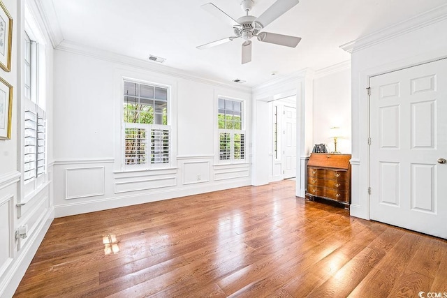 486 Lantana Cir, Georgetown, SC 29440 - unfurnished bedroom with wood finished floors, ornamental molding, a wainscoted wall, and ceiling fan