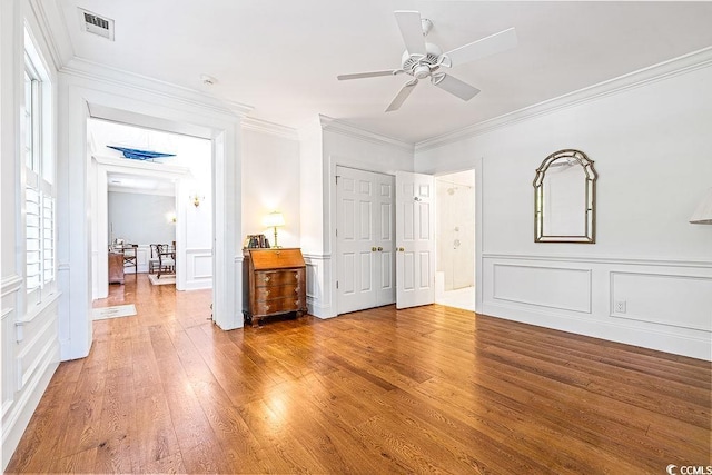 486 Lantana Cir, Georgetown, SC 29440 - unfurnished bedroom featuring a decorative wall, light wood-style flooring, crown molding, a closet, and connected bathroom