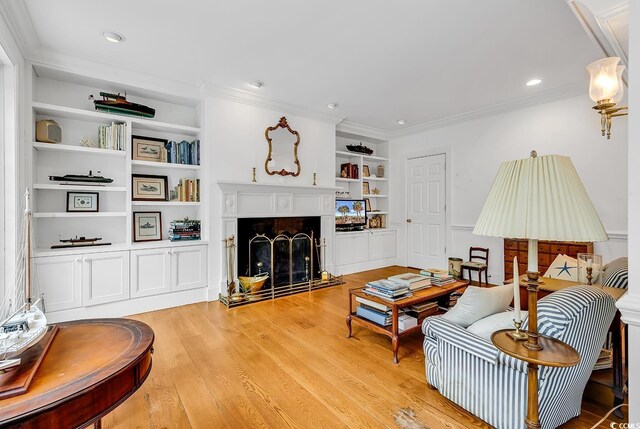 486 Lantana Cir, Georgetown, SC 29440 - living room with crown molding, a fireplace with raised hearth, built in shelves, and light wood-style floors