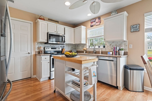 216 Whitchurch St, Murrells Inlet, SC 29576 - kitchen with a sink, white cabinetry, backsplash, and stainless steel appliances