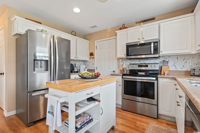 216 Whitchurch St, Murrells Inlet, SC 29576 - kitchen featuring appliances with stainless steel finishes, white cabinetry, decorative backsplash, light wood-type flooring, and visible vents