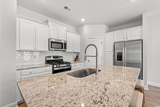 2620 Blue Crane Cir Unit 103, Myrtle Beach, SC 29577 - kitchen with stainless steel appliances, wood finished floors, white cabinets, a kitchen island with sink, and recessed lighting