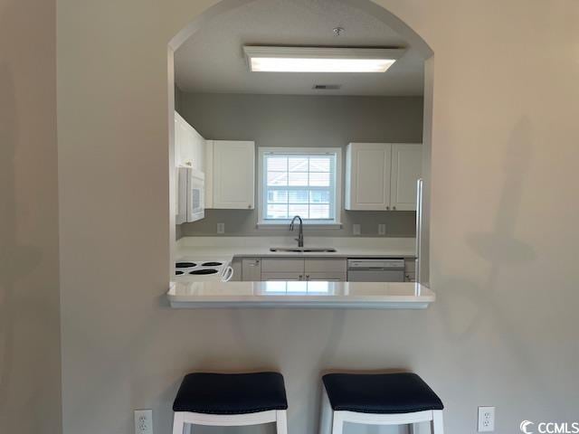 5825 Catalina Dr Unit 234, North Myrtle Beach, SC 29582 - kitchen with stove, arched walkways, stainless steel dishwasher, white microwave, and a sink
