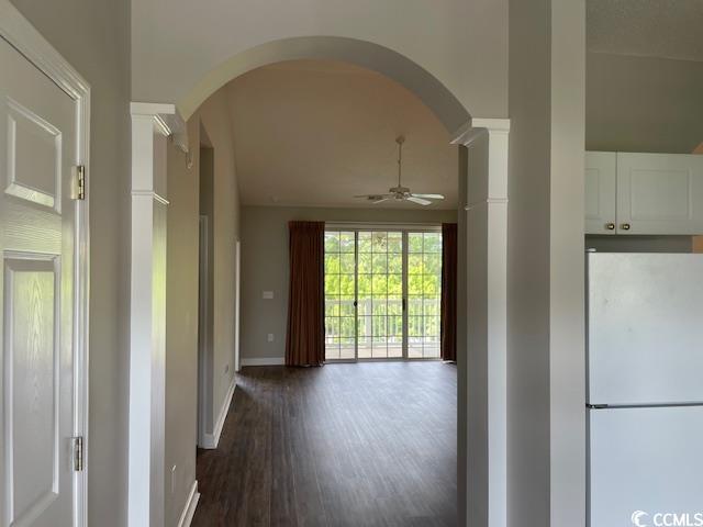 5825 Catalina Dr Unit 234, North Myrtle Beach, SC 29582 - hallway with baseboards, arched walkways, ornate columns, and dark wood finished floors
