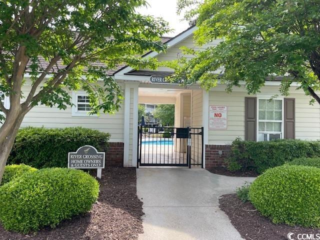 5825 Catalina Dr Unit 234, North Myrtle Beach, SC 29582 - view of exterior entry featuring a gate and brick siding