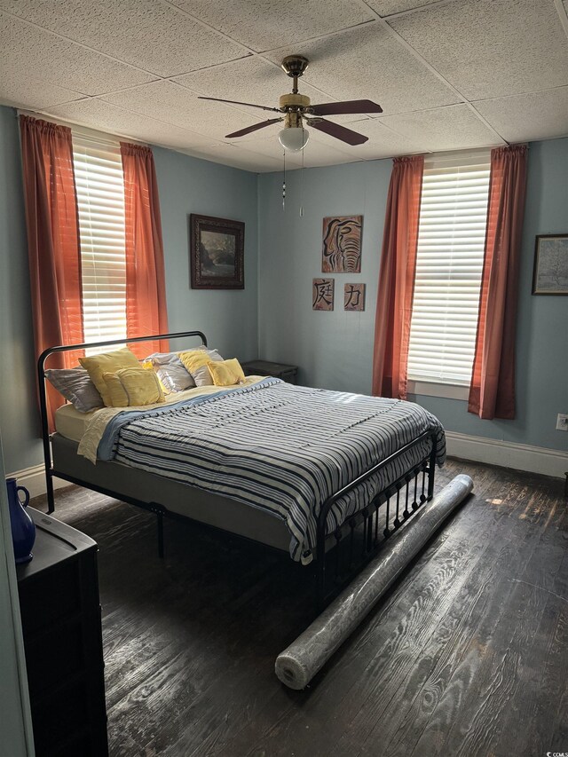 bedroom featuring baseboards, wood finished floors, and ceiling fan