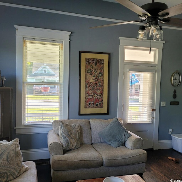 living room featuring baseboards, a ceiling fan, and dark wood-style flooring