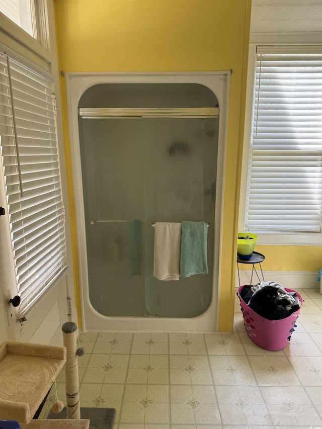 full bathroom with baseboards and a stall shower