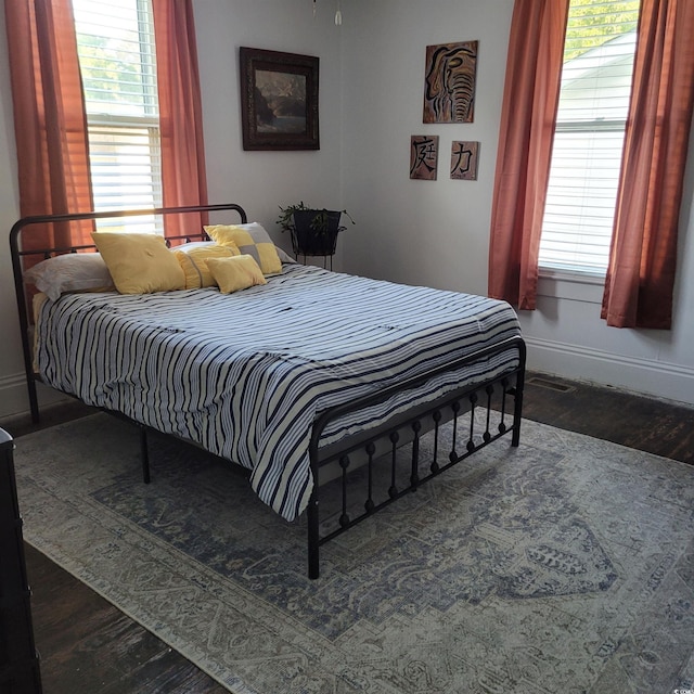 bedroom with baseboards and wood finished floors