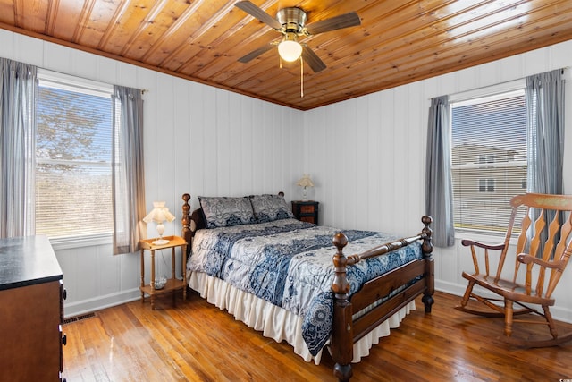 bedroom with wood-type flooring, wood ceiling, multiple windows, baseboards, and ceiling fan