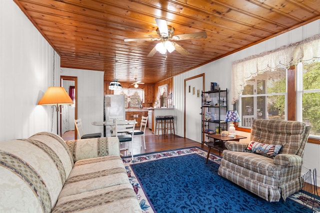 living area with wood ceiling, wood finished floors, a ceiling fan, and wood walls