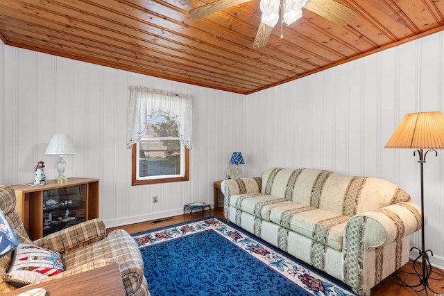 living area featuring wood ceiling, wood finished floors, ceiling fan, and baseboards