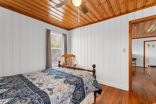 bedroom featuring wood ceiling, baseboards, hardwood / wood-style floors, ornamental molding, and ceiling fan