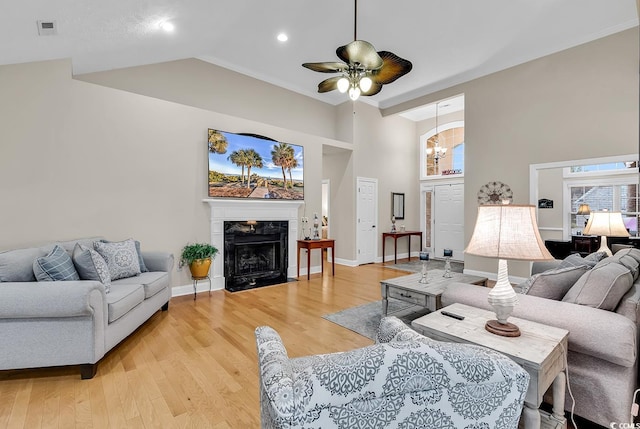 living area featuring recessed lighting, a ceiling fan, light wood finished floors, and a fireplace