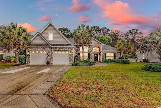view of front of house with brick siding, central AC unit, a front lawn, and concrete driveway