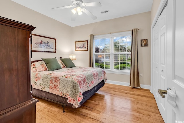 bedroom with visible vents, light wood-style flooring, baseboards, and a closet