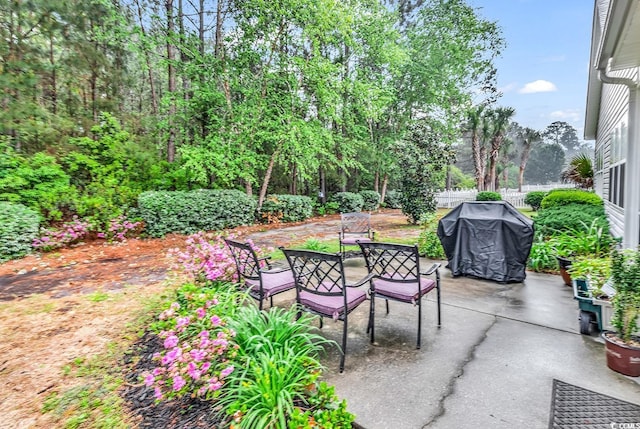 view of patio featuring fence and a grill