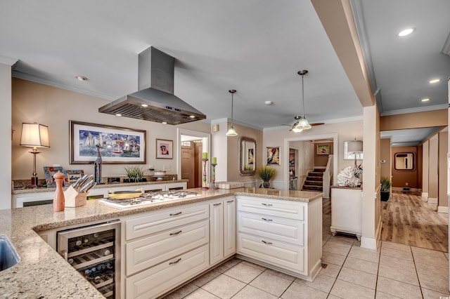 kitchen with ornamental molding, wine cooler, recessed lighting, white gas stovetop, and island exhaust hood