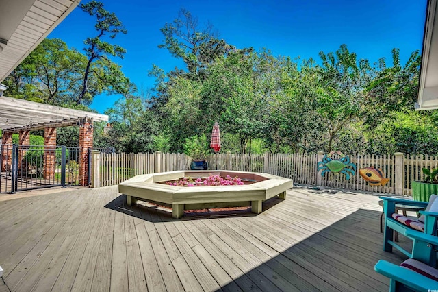 deck with an outdoor fire pit and fence