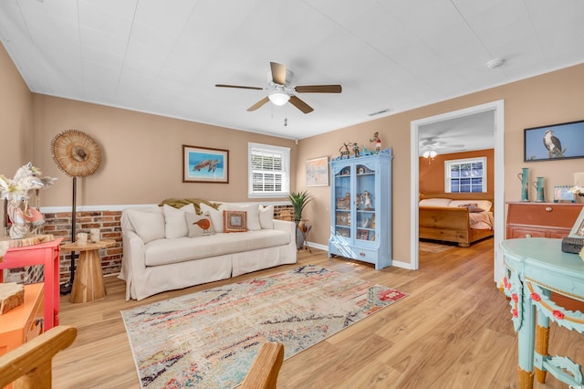 living area with a ceiling fan and wood finished floors