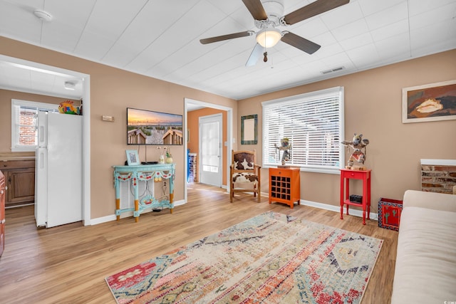 interior space featuring visible vents, baseboards, ceiling fan, and wood finished floors