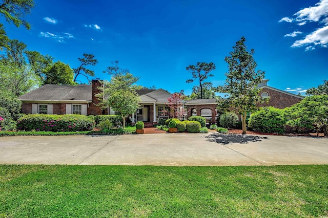 view of front of house with brick siding and a front yard