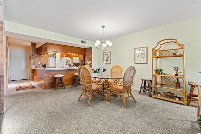 carpeted dining area with a chandelier