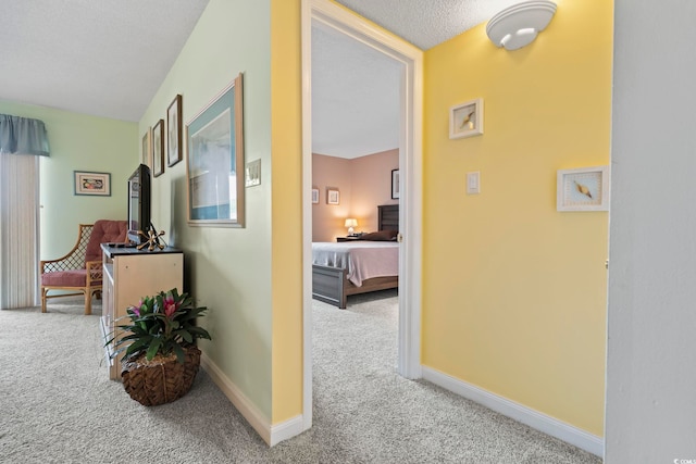 corridor with carpet floors and baseboards