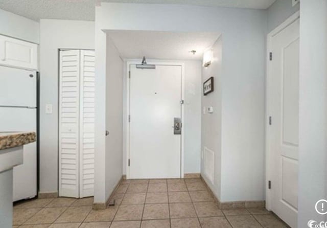 interior space featuring baseboards and light tile patterned floors