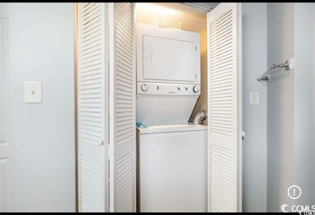 clothes washing area with laundry area and stacked washer and dryer