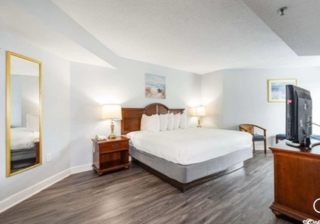 bedroom with baseboards and dark wood-style floors