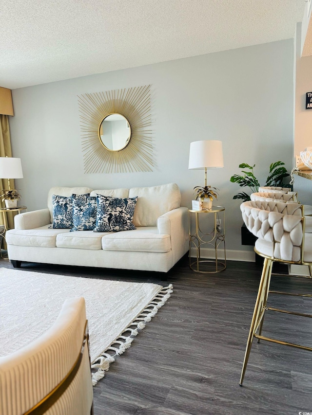 living area featuring baseboards, a textured ceiling, and wood finished floors