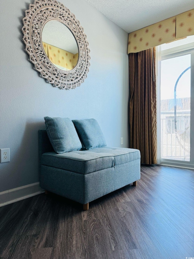 sitting room with baseboards, dark wood-style flooring, and a textured ceiling