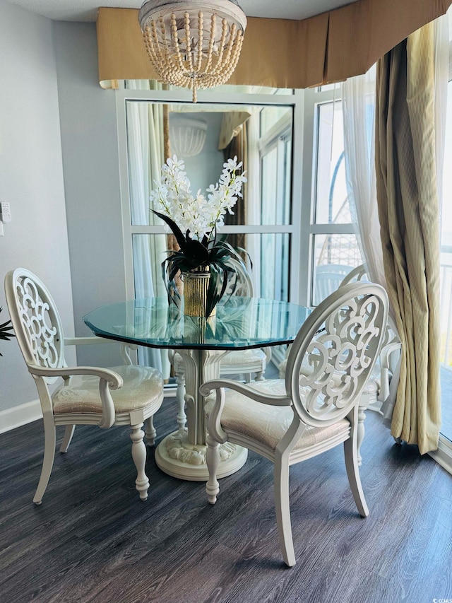 dining space with an inviting chandelier, baseboards, and wood finished floors