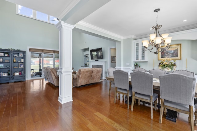 63 Grey Moss Rd, Murrells Inlet, SC 29576 - dining area with decorative columns, a fireplace, a chandelier, wood finished floors, and ornamental molding