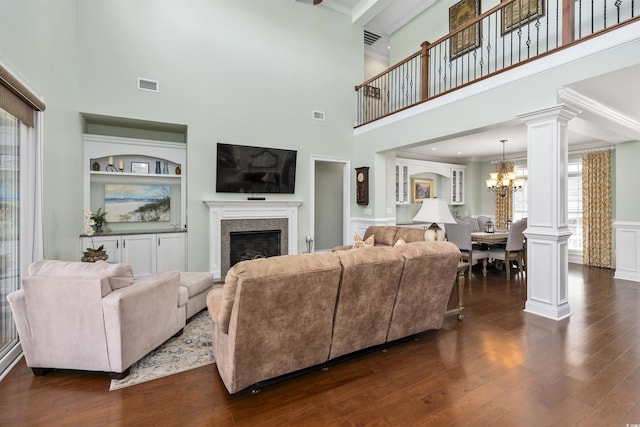 63 Grey Moss Rd, Murrells Inlet, SC 29576 - living room featuring a fireplace, a chandelier, dark wood-style flooring, a high ceiling, and built in shelves