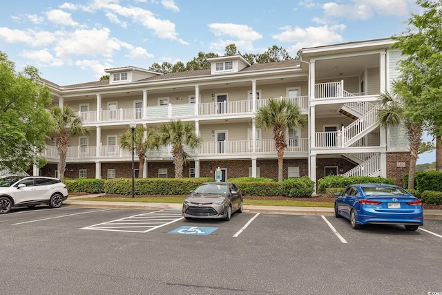 6253 Catalina Dr Unit 131, North Myrtle Beach, SC 29582 - view of building exterior with uncovered parking and stairway