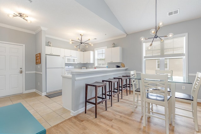 6253 Catalina Dr Unit 131, North Myrtle Beach, SC 29582 - kitchen with white appliances, white cabinets, visible vents, a notable chandelier, and crown molding