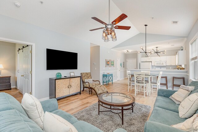 6253 Catalina Dr Unit 131, North Myrtle Beach, SC 29582 - living room with light wood-style flooring, ceiling fan with notable chandelier, baseboards, visible vents, and lofted ceiling