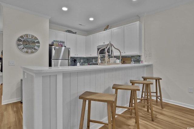 601 Hillside Dr N Unit 1405, North Myrtle Beach, SC 29582 - kitchen featuring appliances with stainless steel finishes, decorative backsplash, a peninsula, and a kitchen breakfast bar